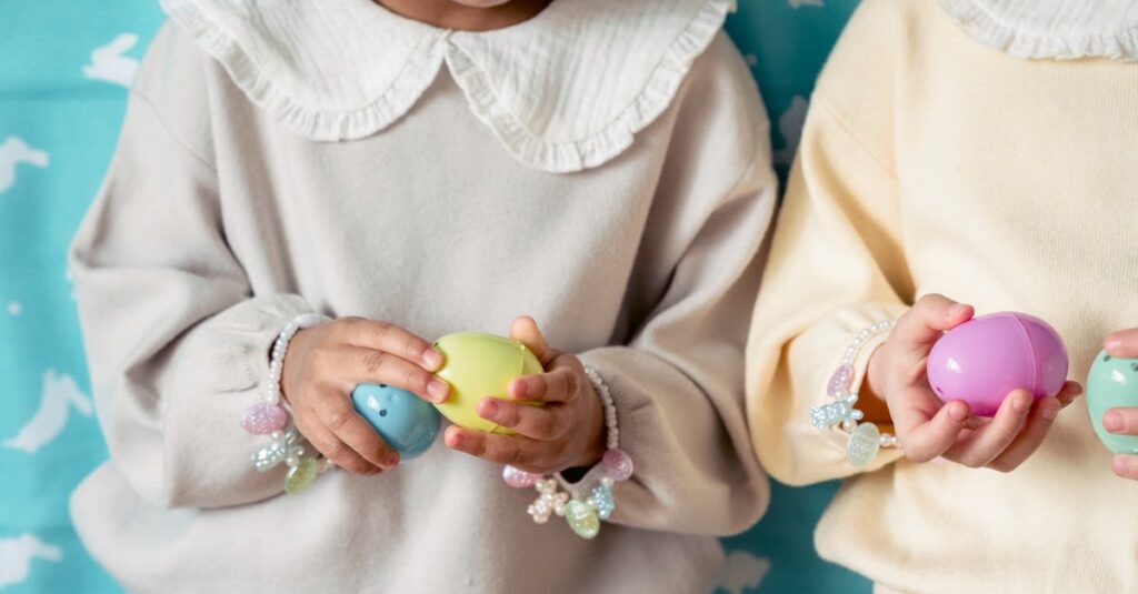 Crop unrecognizable multiracial children in similar wear with accessories and colorful painted eggs during festive event
